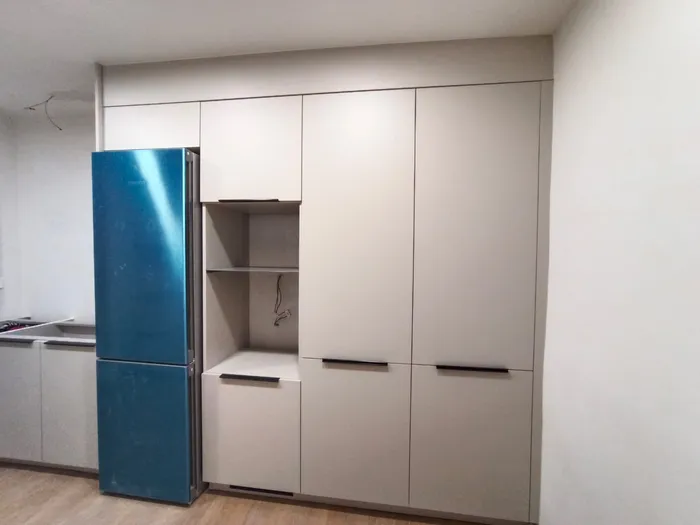 Armario de cocina blanco con nicho junto a nevera combi