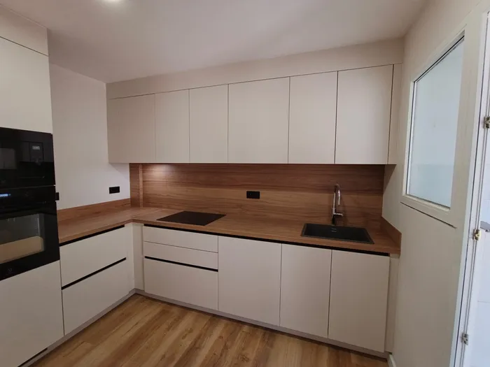 Cocina en L con muebles de madera nogal y electrodomésticos integrados
