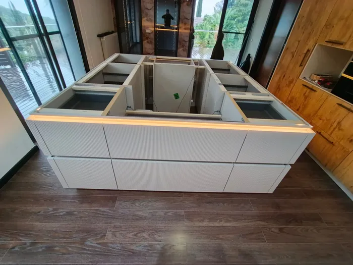Montaje de isla de cocina blanca con iluminación LED perimetral