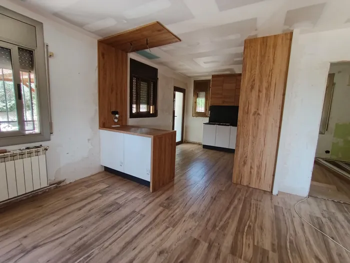 Salón-cocina abierto con mueble de madera a medida